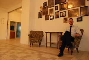 Dutch hotel manager Sebastiaan de Vos knows each of the 20 refugees. Their photos hang on the wall behind him.